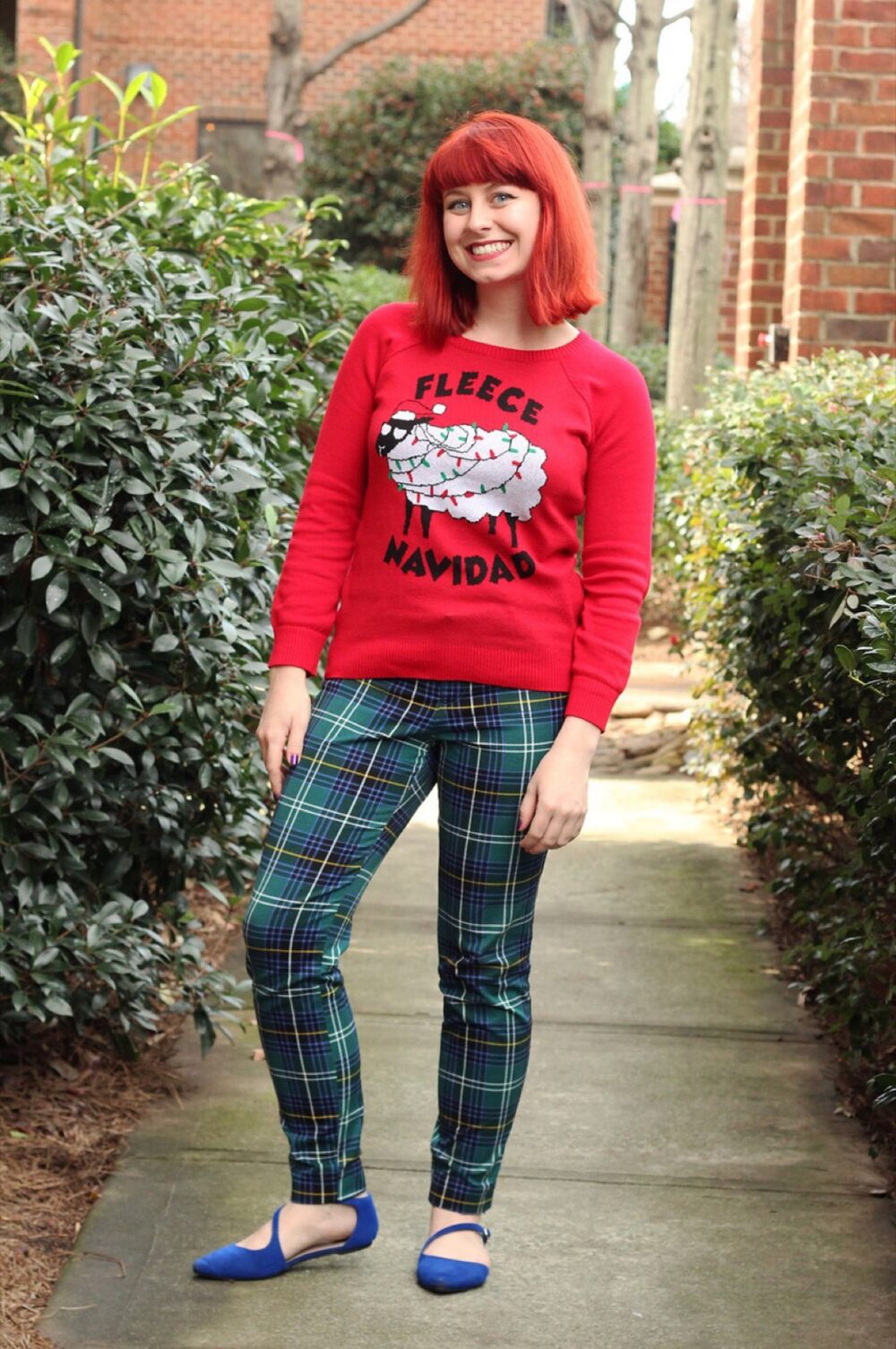 Heavily embellished red Christmas sweater paired with green plaid pants