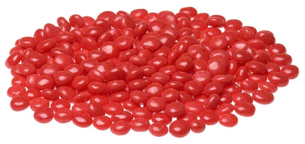 Bulk red cinnamon candies in retail packaging, illustrating typical case-packed wholesale supply