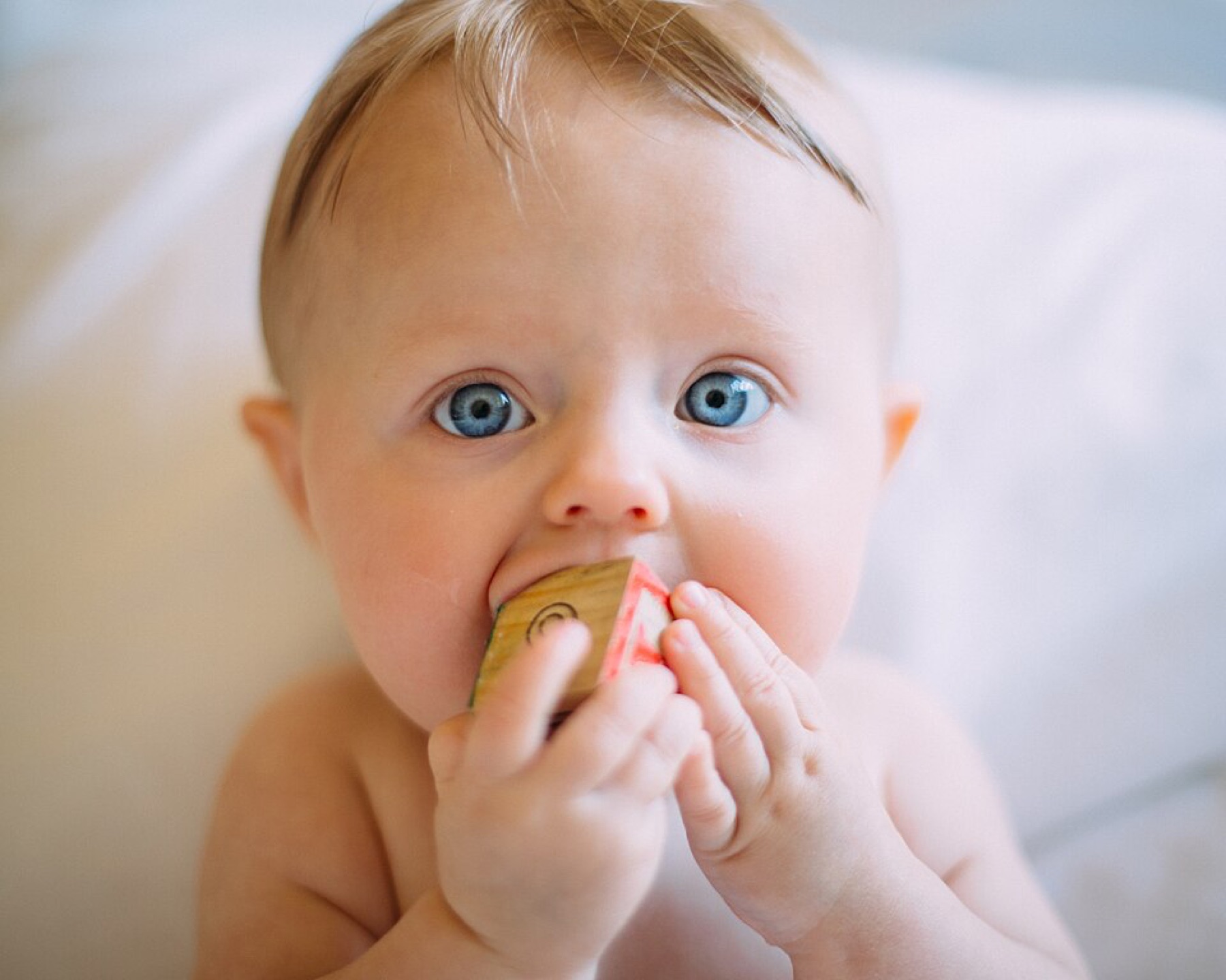 Assorted baby toys laid out on a soft surface