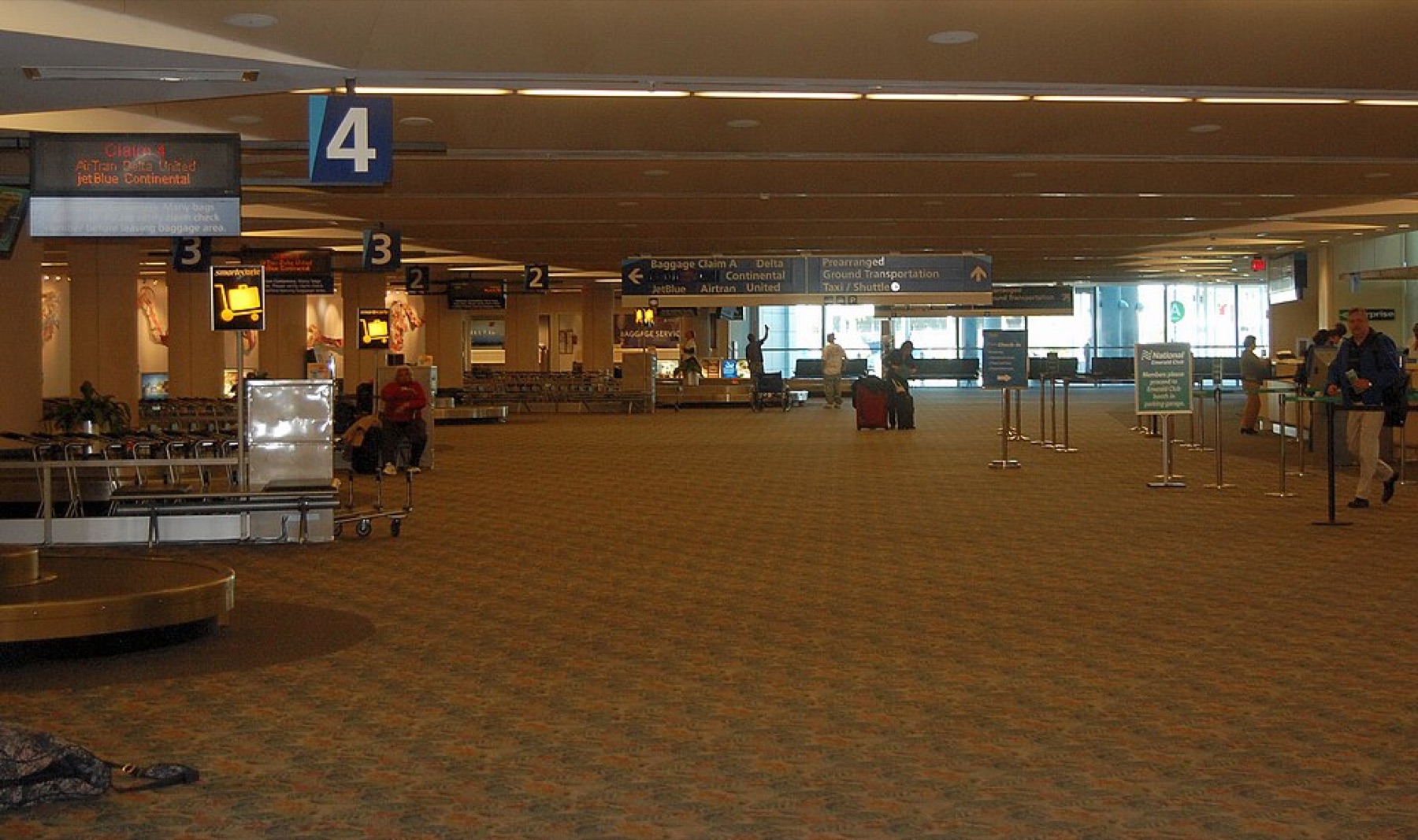 Stacked travel bags in an airport claim area, illustrating everyday handbag use