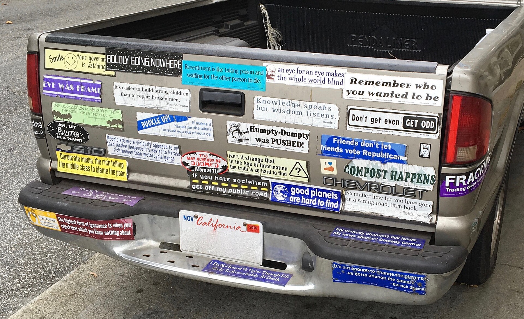 Rear view of a Chevrolet truck with multiple bumper stickers emphasizing bumper area