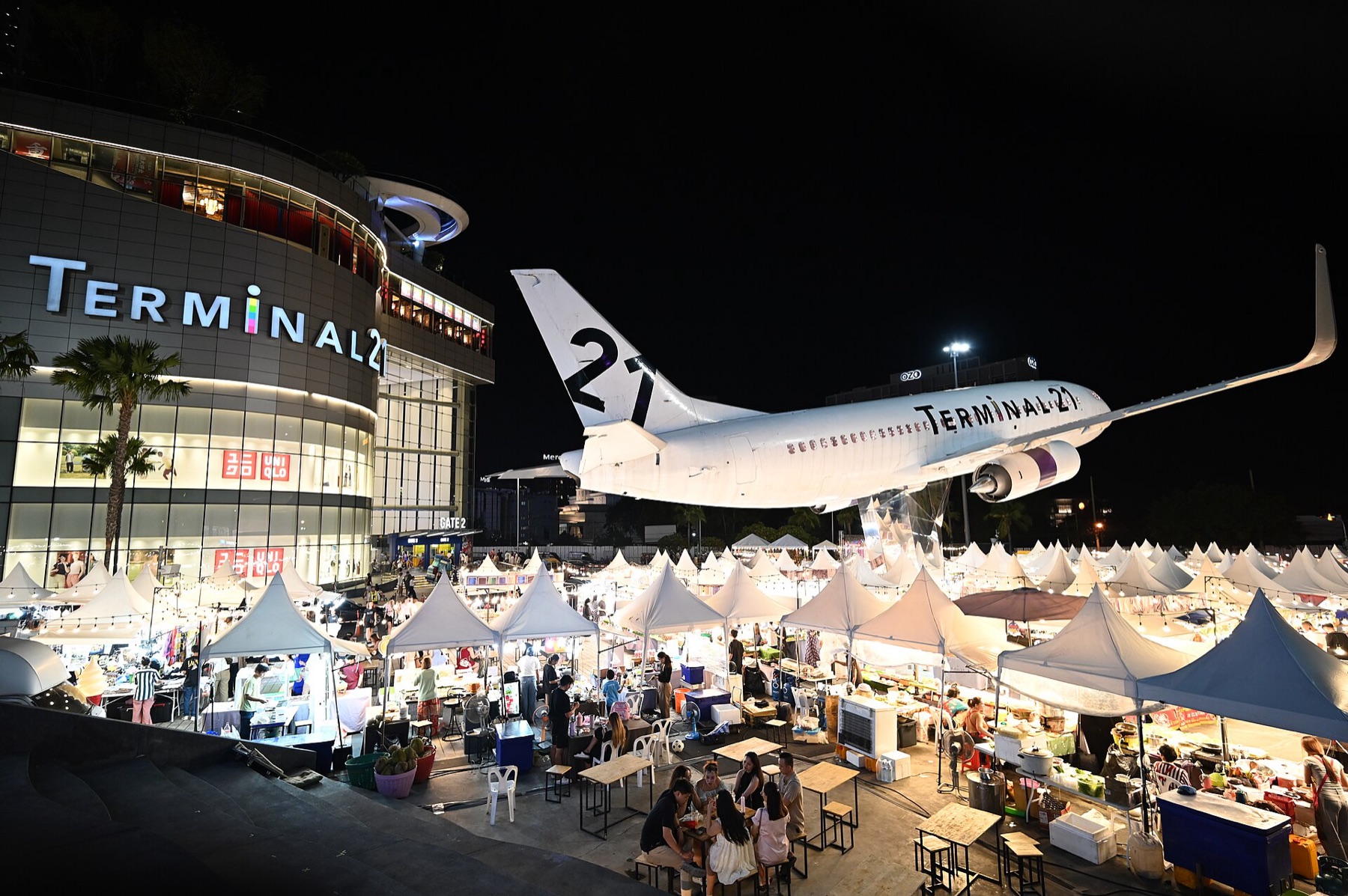 Rows of white vendor tents at a busy night market, illustrating typical canopy structures