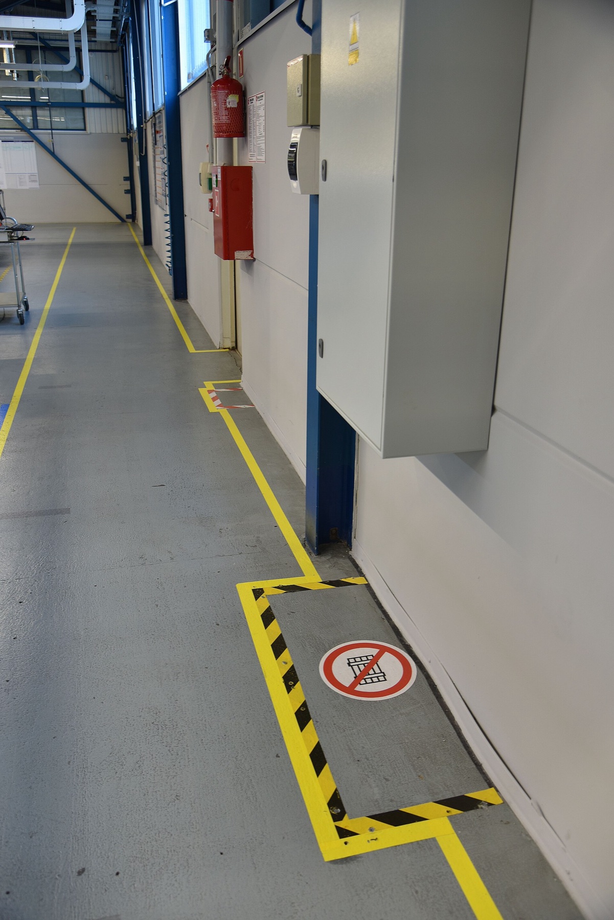 Industrial floor safety markings in a factory environment.