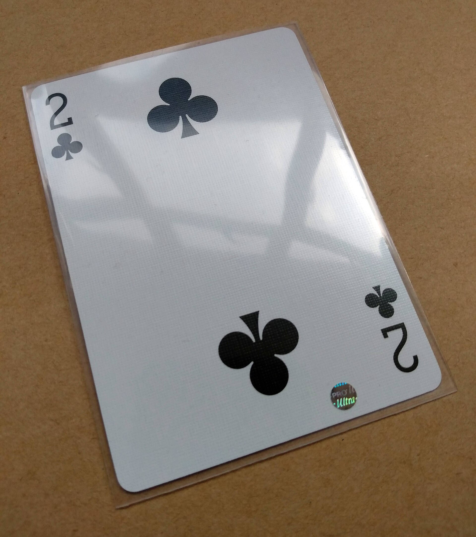 Playing card protected inside a clear plastic card sleeve