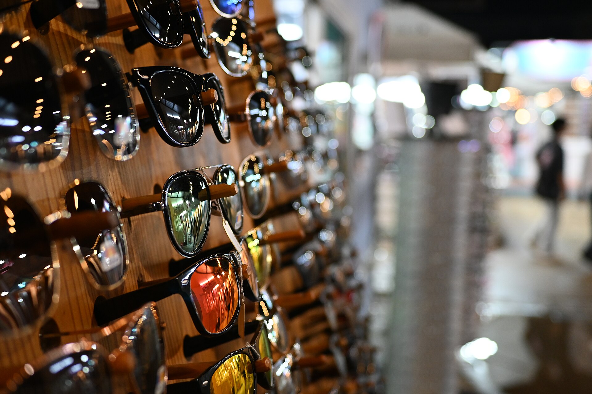 Assorted sunglasses styles on a rack, showing how frame and lens choices affect price and quality.