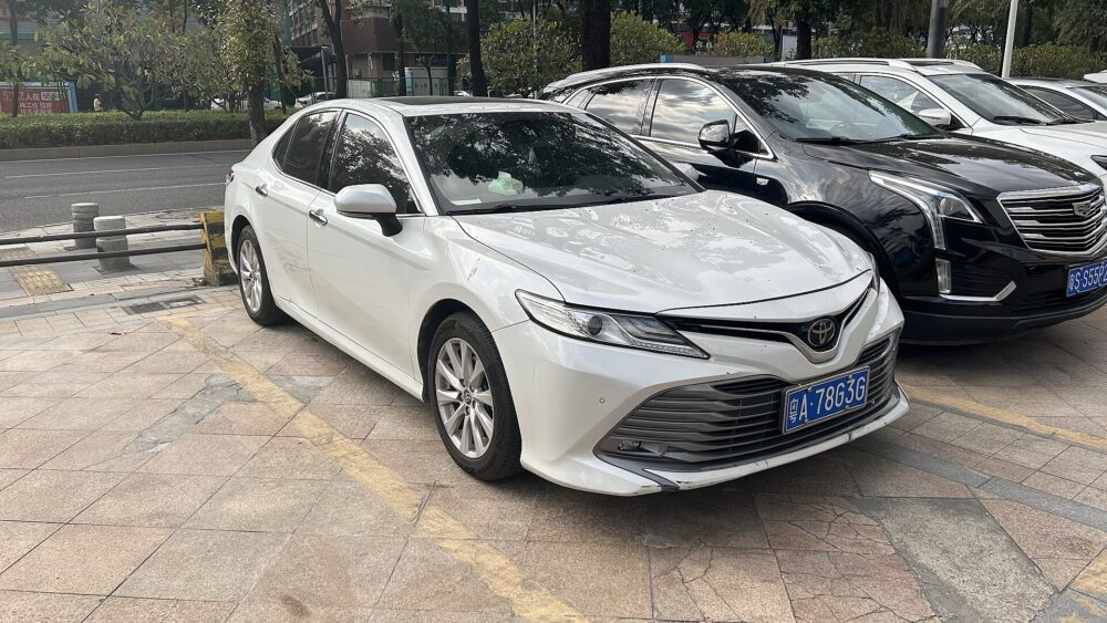 Front view of a Toyota Camry showing the bumper cover, grille, lower intake, and sensor mounting areas