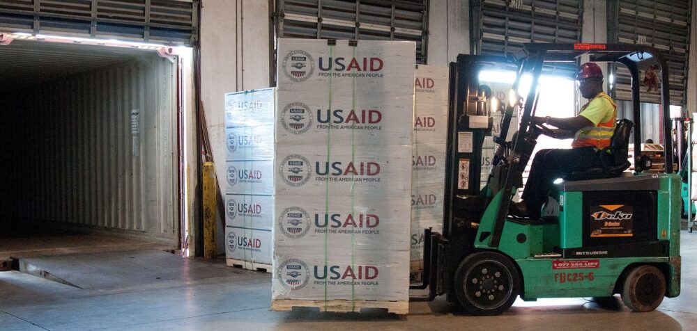 Forklifts moving palletized goods through a large warehouse